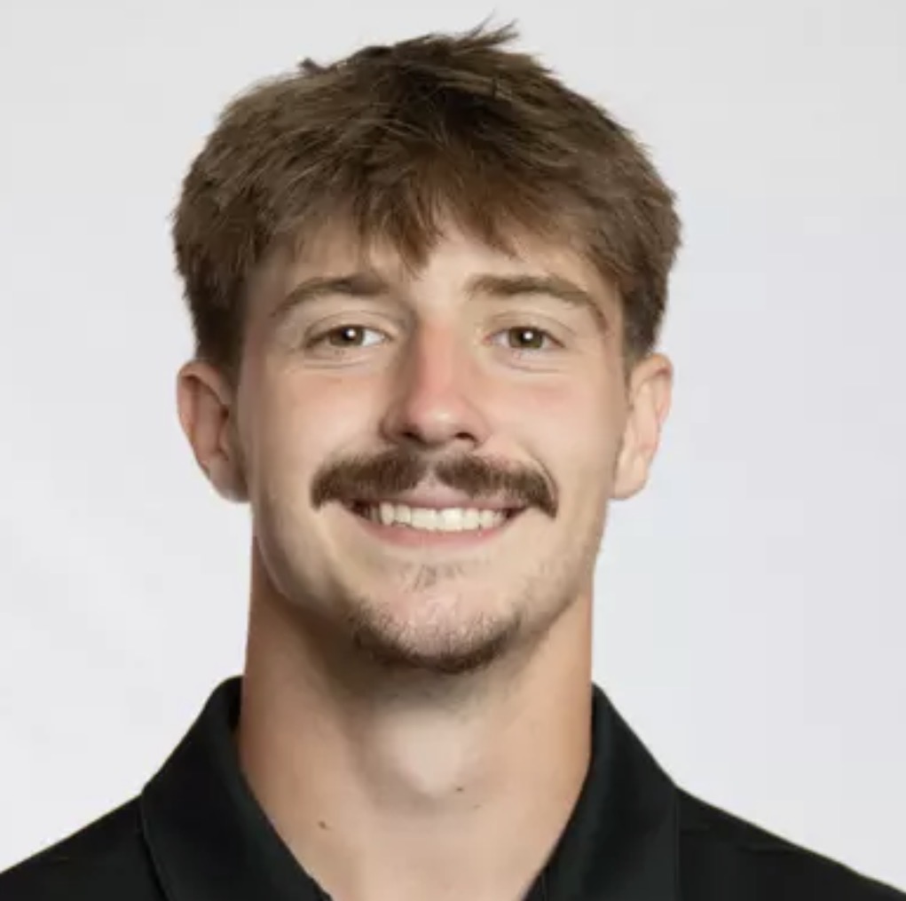 Jeremy Sherlock, smiling headshot in a black polo